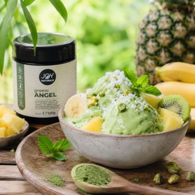 Vegane Nice Cream aus Banane und Ananas mit green:ANGEL von JOY Naturals – cremiges hellgrünes Eis mit Kokos, Pistazien und frischen Früchten.
Natürliches Rezeptbild einer veganen Green Nice Cream mit Ananas, Banane und green:ANGEL Pulver von JOY Naturals – sommerlich, cremig und tropisch dekoriert.