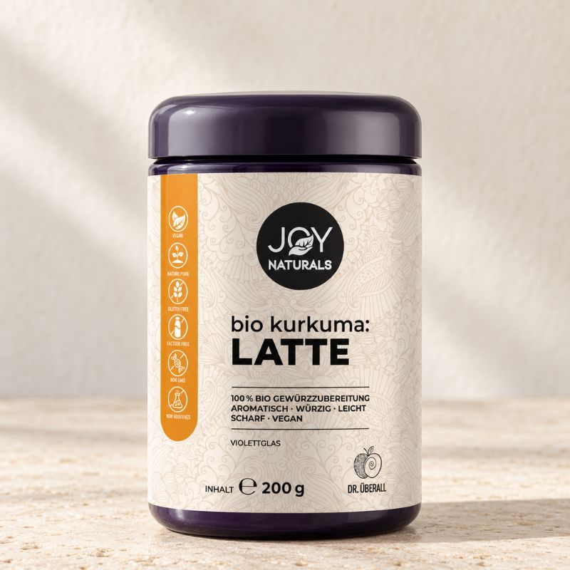 JOY NATURALS Bio Kurkuma Latte für Goldene Milch – 200 g im Violettglas auf hellem Naturstein.